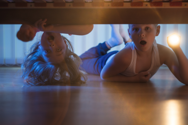 kinderen kijken onder het bed